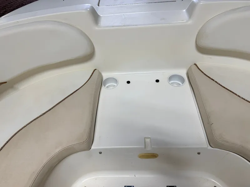 Slide: The Image of Interior view of a Glastron DX215 deck boat with beige seating and cup holders. - 20