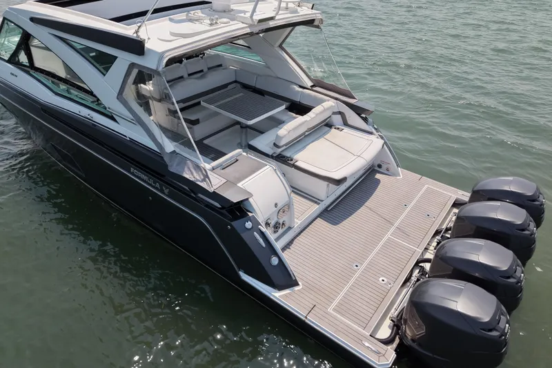 Slide: The Image of 2019 Formula 430 Super Sport Crossover boat on water, featuring spacious deck and multiple engines. - 79