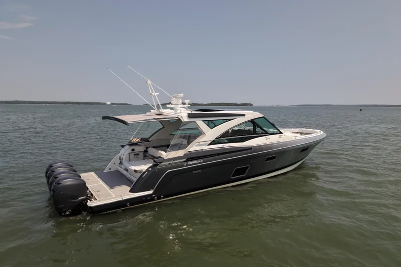 Slide: The Image of 2019 Formula 430 Super Sport Crossover boat on calm water, showcasing sleek design and powerful engines. - 3