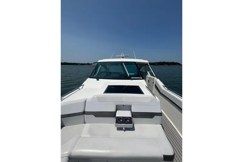 Slide: The Image of 2019 Formula 430 Super Sport Crossover boat on calm water under clear blue sky. - 50
