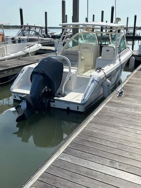 Slide: The Image of A 2012 Pursuit DC 265 Dual Console boat docked at a marina. - 9