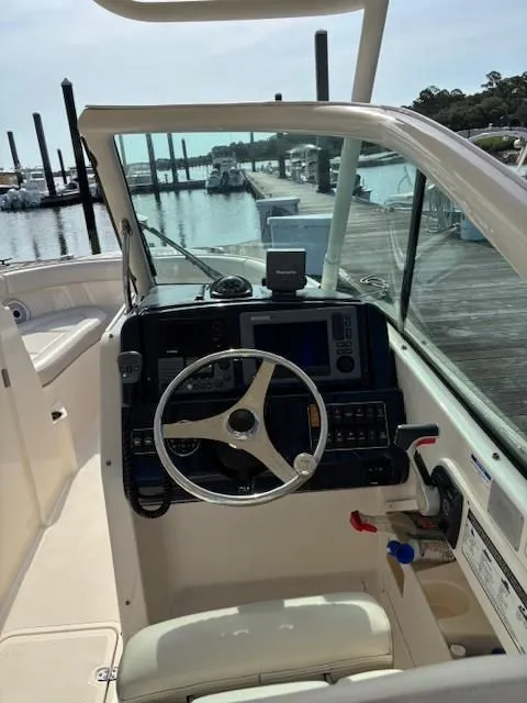 Slide: The Image of The cockpit of a 2012 Pursuit DC 265 Dual Console with steering wheel and instruments. - 4