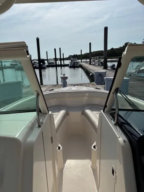 Slide: The Image of View from inside a Pursuit DC 265 Dual Console boat looking out at a calm marina. - 5
