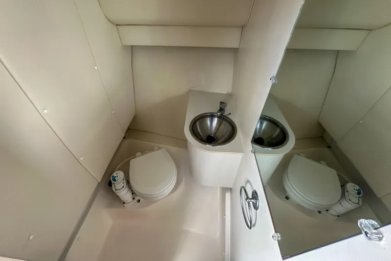 Slide: The Image of Compact bathroom in a 2001 Tiara Yachts 2900 Coronet, featuring a toilet and stainless steel sink. - 24