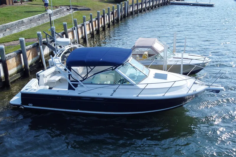 Slide: The Image of 2001 Tiara Yachts 2900 Coronet docked, featuring sleek design and blue canopy. - 2