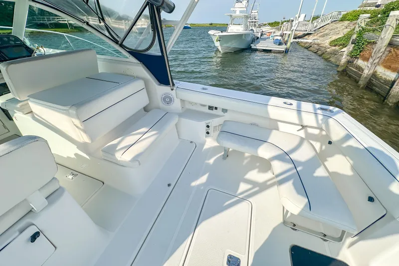 Slide: The Image of 2001 Tiara Yachts 2900 Coronet interior with white seating, docked by the water. - 11