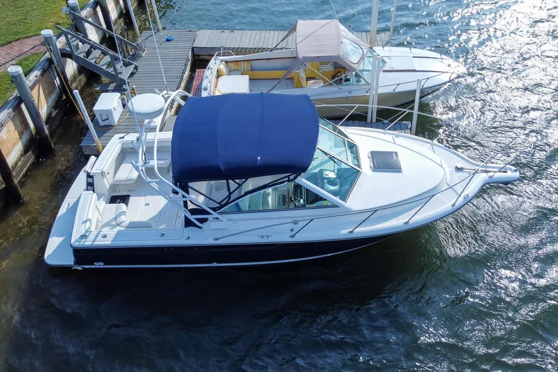 Slide: The Image of 2001 Tiara Yachts 2900 Coronet docked, featuring a blue canopy and sleek design. - 36
