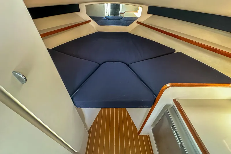 Slide: The Image of 2001 Tiara Yachts 2900 Coronet cabin interior with blue cushions and wooden accents. - 23