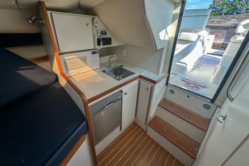 Slide: The Image of 2001 Tiara Yachts 2900 Coronet interior with kitchenette, sink, microwave, and wooden steps. - 22