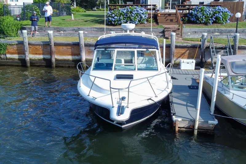 Slide: The Image of 2001 Tiara Yachts 2900 Coronet docked by waterfront with lush greenery. - 7