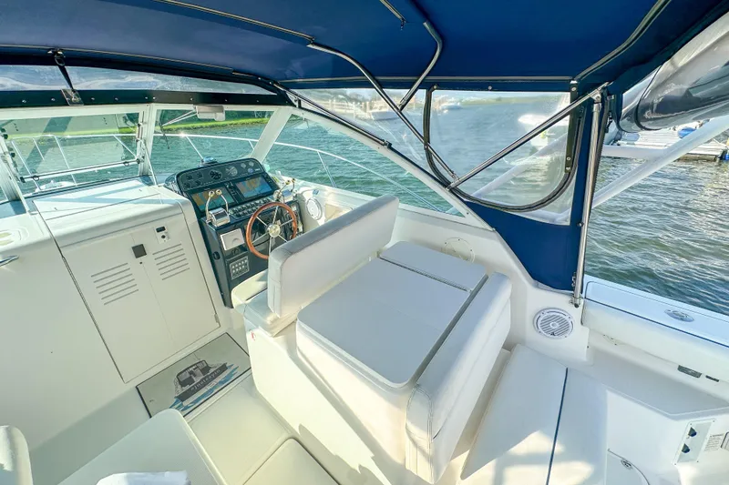 Slide: The Image of 2001 Tiara Yachts 2900 Coronet interior with helm, seating, and blue canopy. - 10