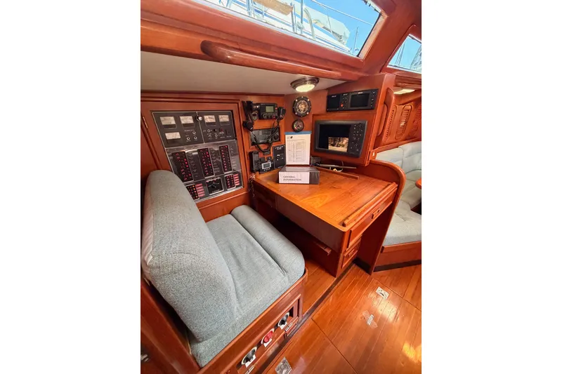 Slide: The Image of Navigation station of a 1991 Hylas 51 yacht with control panels and seating. - 59