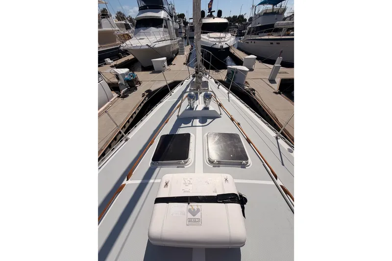 Slide: The Image of 1991 Hylas 51 yacht deck view at marina, showcasing sleek design and docked boats. - 12