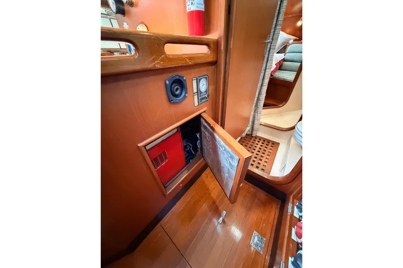 Slide: The Image of Interior of 1991 Hylas 51 yacht showing wooden paneling and storage compartment. - 66