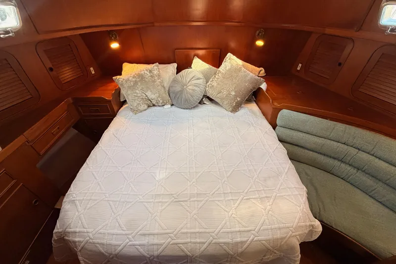 Slide: The Image of Cozy cabin interior of a 1991 Hylas 51 yacht with elegant bedding and warm lighting. - 74