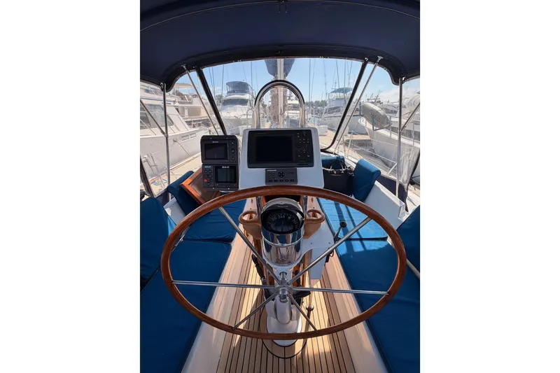 Slide: The Image of Cockpit of a 1991 Hylas 51 yacht with wooden steering wheel and navigation equipment. - 42