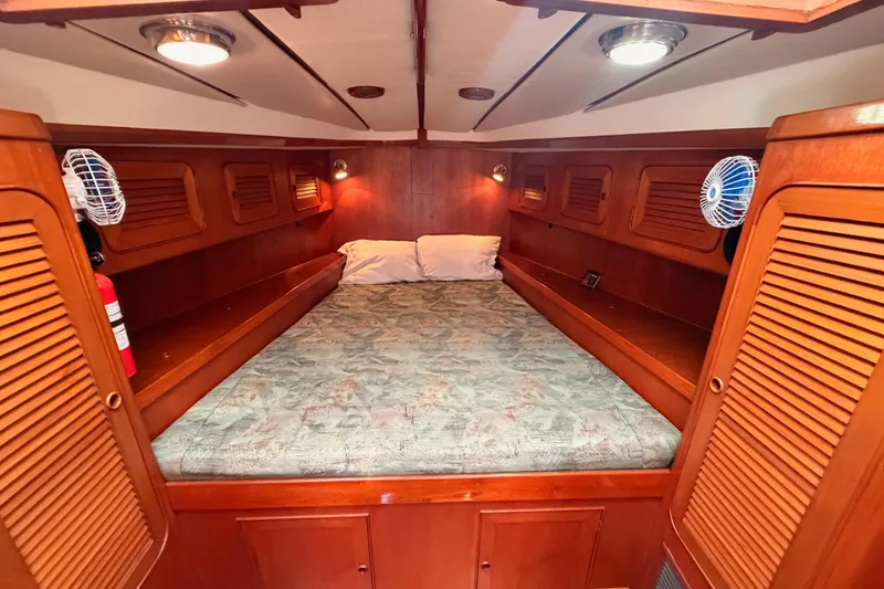 Slide: The Image of Cozy cabin interior of a 1991 Hylas 51 yacht with wood paneling and bedding. - 102