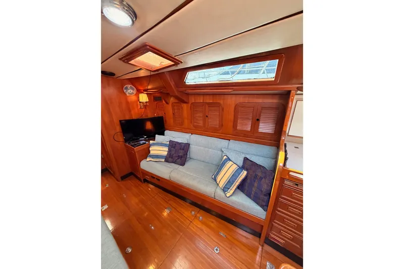 Slide: The Image of Interior of 1991 Hylas 51 yacht with cozy seating, wooden finish, and TV setup. - 94