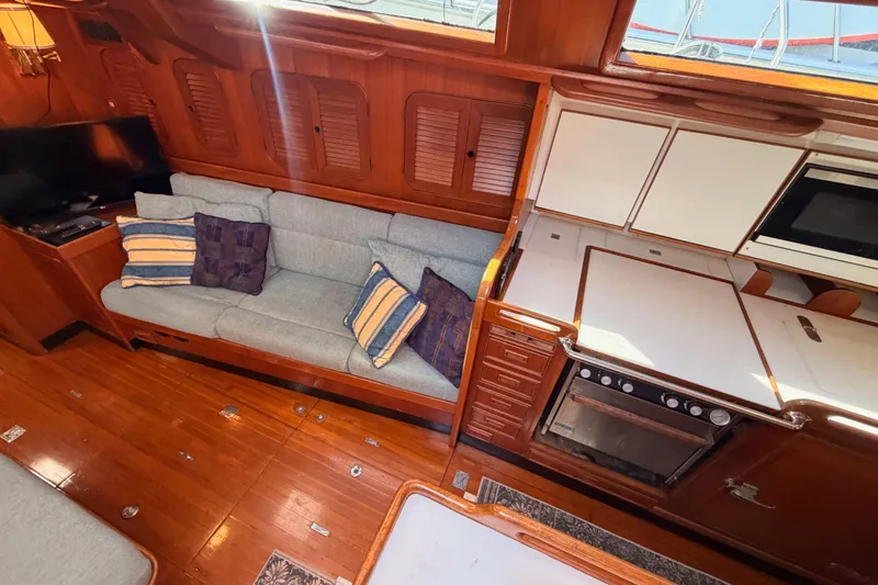 Slide: The Image of Interior of 1991 Hylas 51 yacht with cozy seating and modern kitchen amenities. - 51