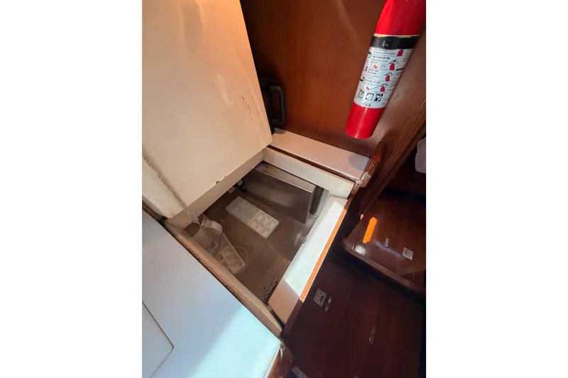 Slide: The Image of Interior of a 1991 Hylas 51 yacht featuring a built-in storage compartment and fire extinguisher. - 80