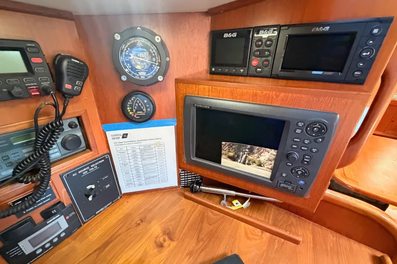 Slide: The Image of Navigation equipment and controls inside a 1991 Hylas 51 yacht cabin. - 62