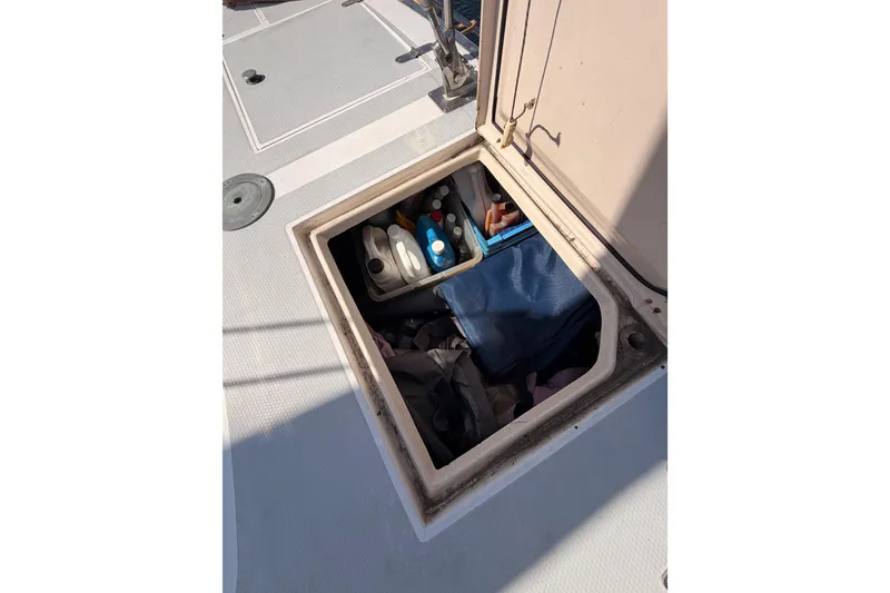 Slide: The Image of Open storage compartment on 1991 Hylas 51 yacht deck with various supplies. - 30
