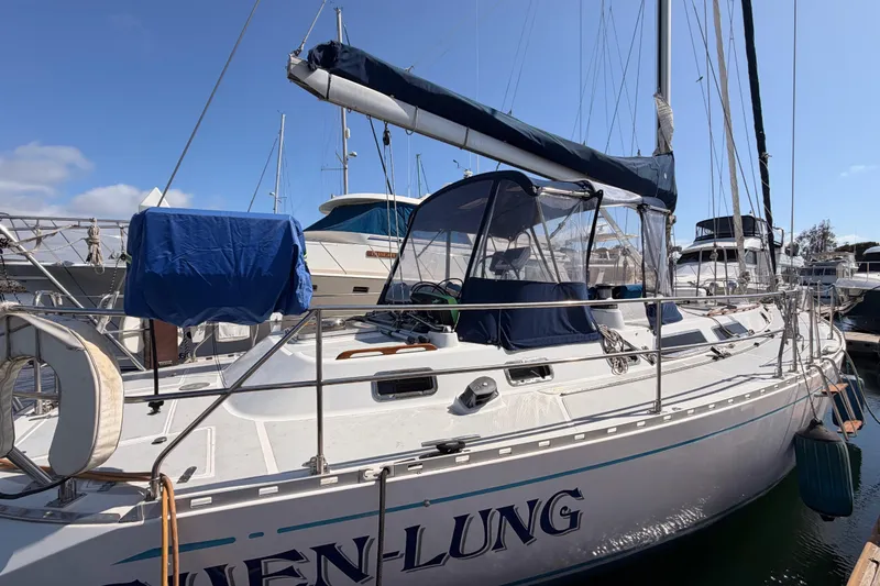 Slide: The Image of Sailboat docked at marina, Hylas 51 model from 1991, under clear blue sky. - 9
