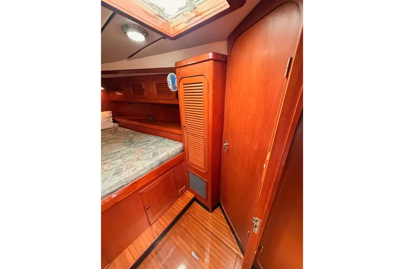 Slide: The Image of Interior cabin of 1991 Hylas 51 yacht with wooden finishes and cozy bed. - 103