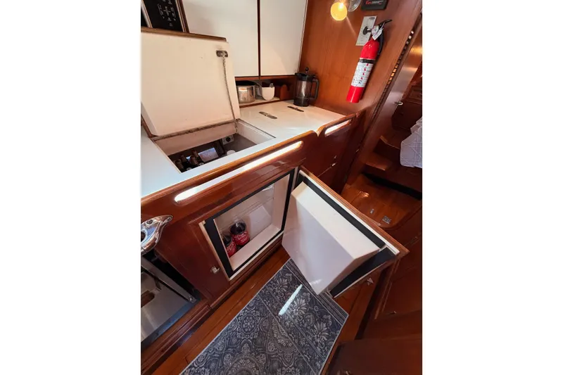 Slide: The Image of Interior of 1991 Hylas 51 yacht kitchen with open fridge and fire extinguisher. - 81