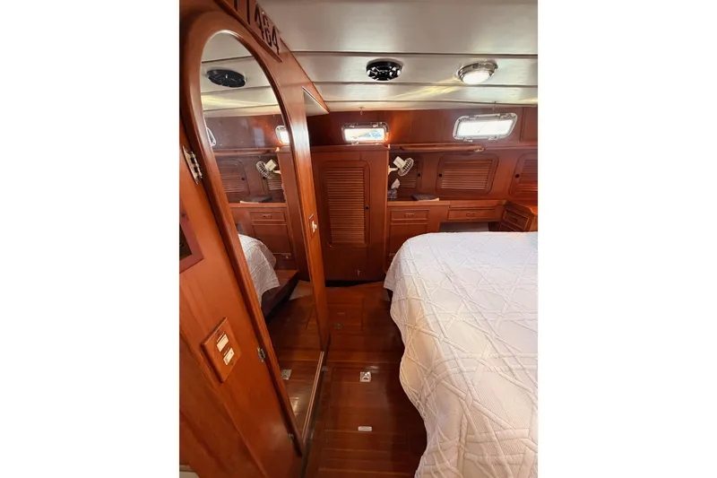 Slide: The Image of Luxurious wooden interior of a 1991 Hylas 51 yacht cabin with bed and storage. - 73