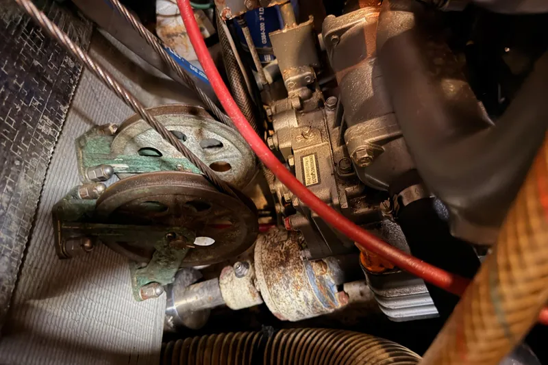 Slide: The Image of Engine components of a 1991 Hylas 51 yacht, featuring belts and hoses. - 89