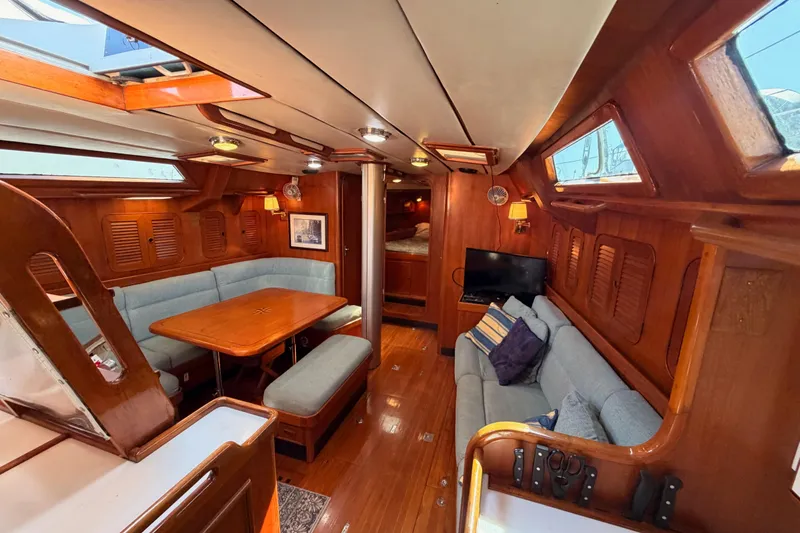 Slide: The Image of Luxurious 1991 Hylas 51 yacht interior with wooden finishes and cozy seating area. - 93