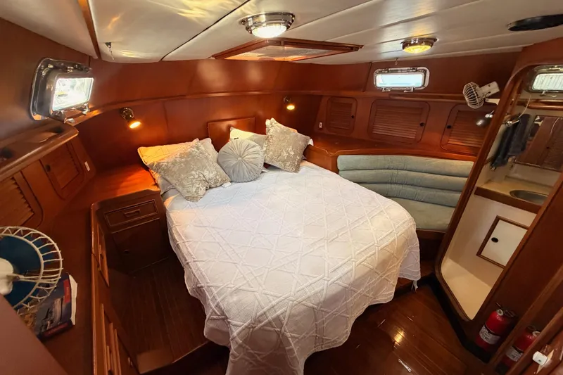 Slide: The Image of Luxurious 1991 Hylas 51 yacht cabin with cozy bed and elegant wood finish. - 77
