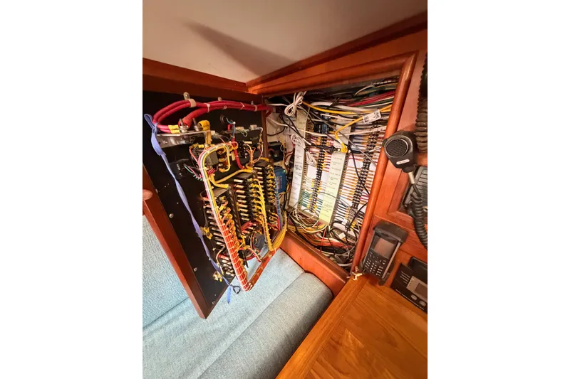 Slide: The Image of Electrical panel of a 1991 Hylas 51 yacht, showcasing intricate wiring and components. - 63