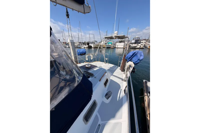 Slide: The Image of Sailboat Hylas 51, 1991 model, docked in a marina with clear blue skies. - 23