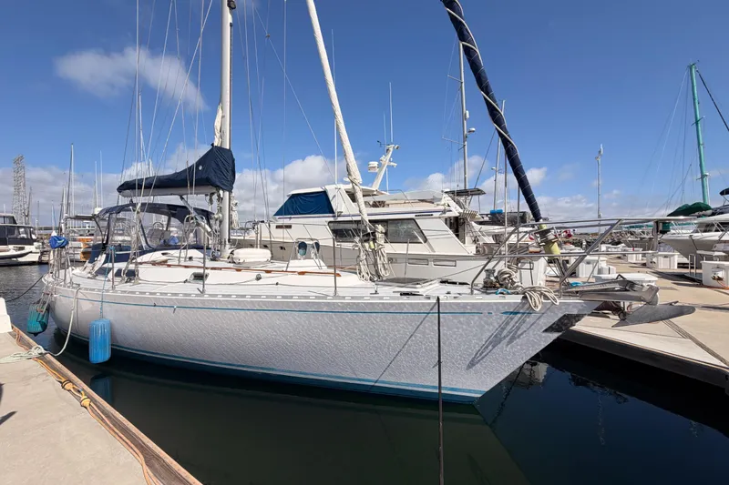 Slide: The Image of Sailboat docked at marina, Hylas 51 model from 1991, under clear blue sky. - 3