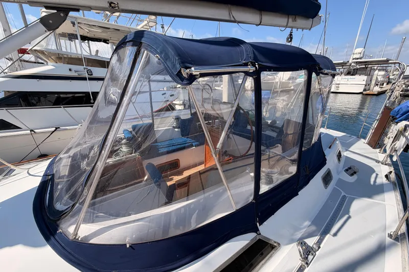 Slide: The Image of 1991 Hylas 51 sailboat with blue canopy docked at marina. - 24