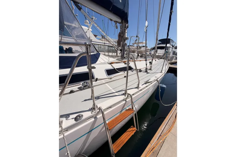 Slide: The Image of Sleek 1991 Hylas 51 sailboat docked, showcasing polished deck and rigging. - 10