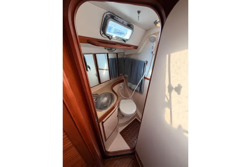 Slide: The Image of Bathroom interior of a 1991 Hylas 51 yacht, featuring sink, toilet, and shower. - 104