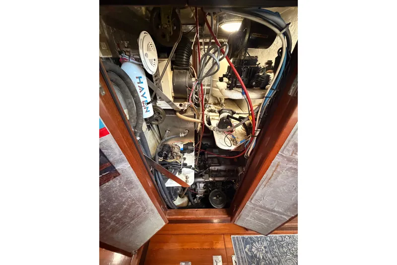 Slide: The Image of Engine compartment of a 1991 Hylas 51 yacht, showcasing wiring and mechanical components. - 86