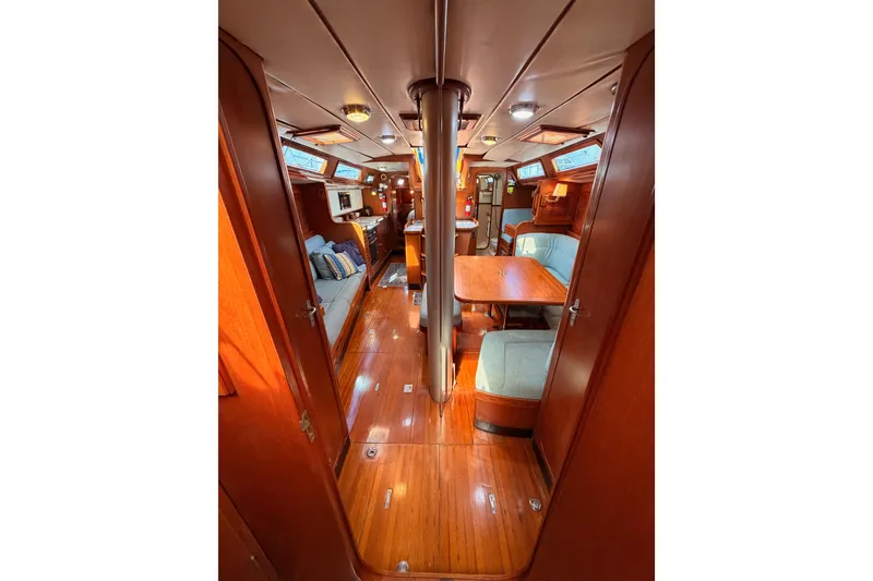 Slide: The Image of Interior of 1991 Hylas 51 yacht, featuring polished wood and cozy seating area. - 106