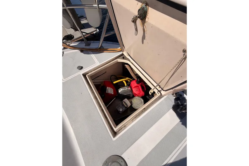 Slide: The Image of Open storage compartment on 1991 Hylas 51 yacht deck, containing various tools and equipment. - 31