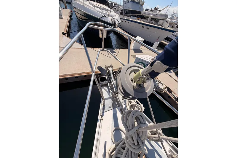 Slide: The Image of Bow of 1991 Hylas 51 yacht with ropes and docked boats in background. - 18