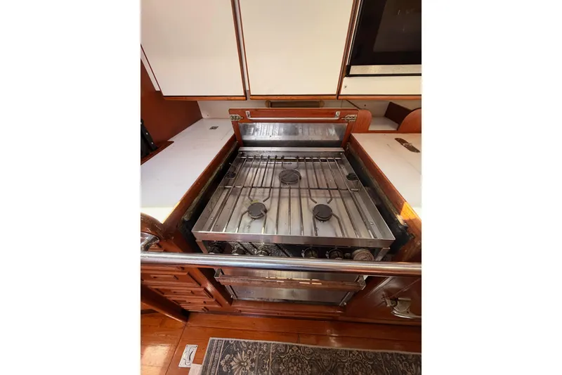 Slide: The Image of Stainless steel stove in a 1991 Hylas 51 yacht kitchen, featuring wooden cabinetry. - 84