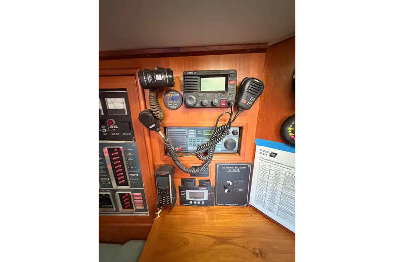 Slide: The Image of 1991 Hylas 51 yacht navigation and communication equipment panel with various controls and devices. - 61