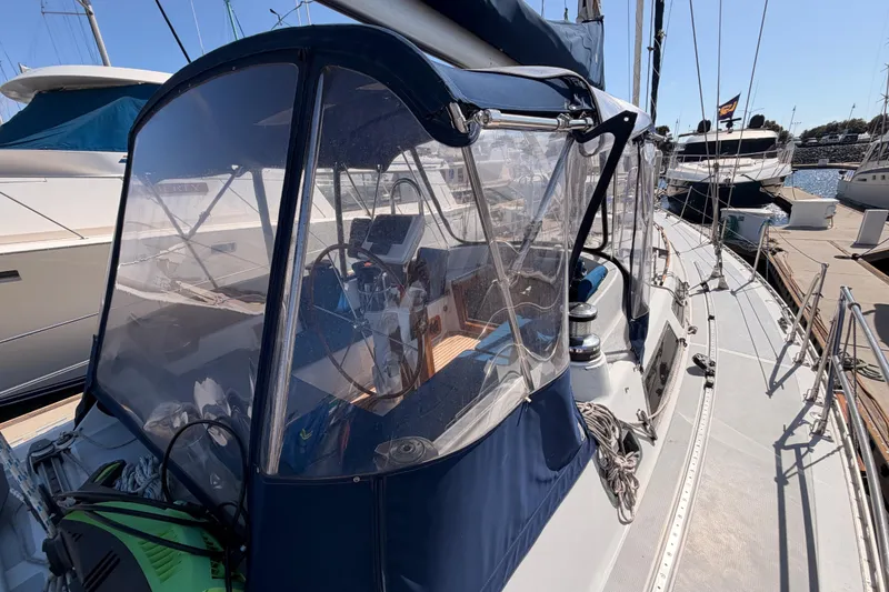 Slide: The Image of Sailboat cockpit of a 1991 Hylas 51, featuring a clear enclosure and marina view. - 39