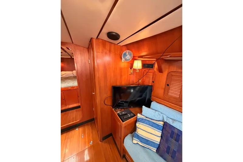 Slide: The Image of Interior of 1991 Hylas 51 yacht with wooden paneling, TV, and cozy seating area. - 96