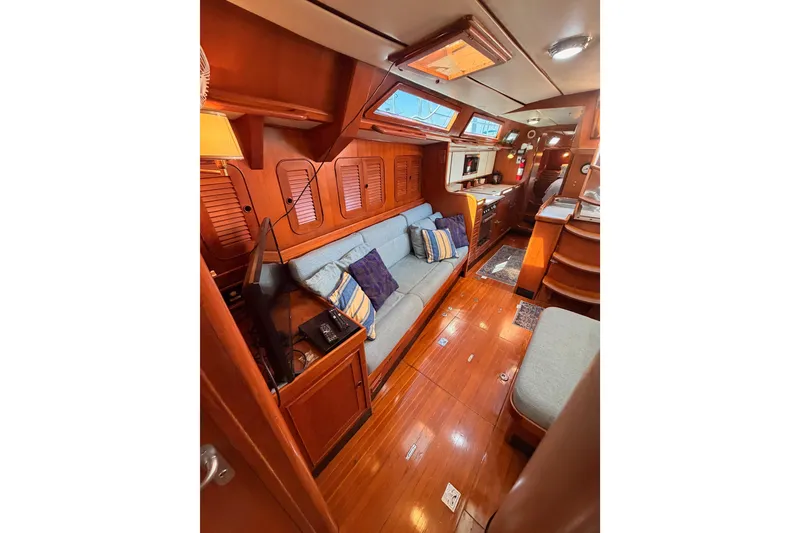 Slide: The Image of Luxurious 1991 Hylas 51 yacht interior with wooden finishes and cozy seating area. - 109
