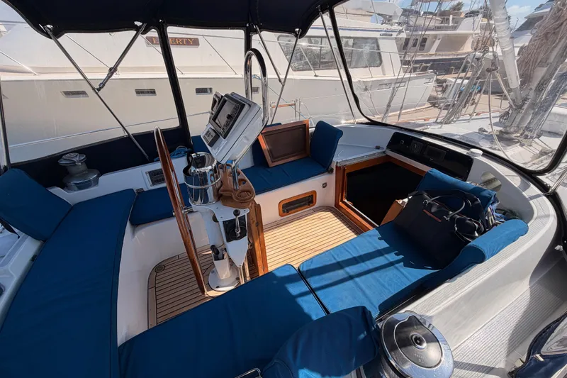 Slide: The Image of Cockpit of a 1991 Hylas 51 yacht with blue seating and navigation equipment. - 40