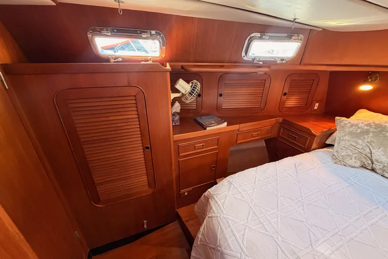 Slide: The Image of Cozy cabin interior of a 1991 Hylas 51 yacht with wooden cabinetry and bedding. - 75